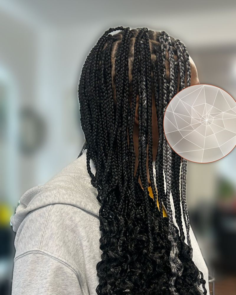 Boho knotless braids with grey highlights and curly ends, side view