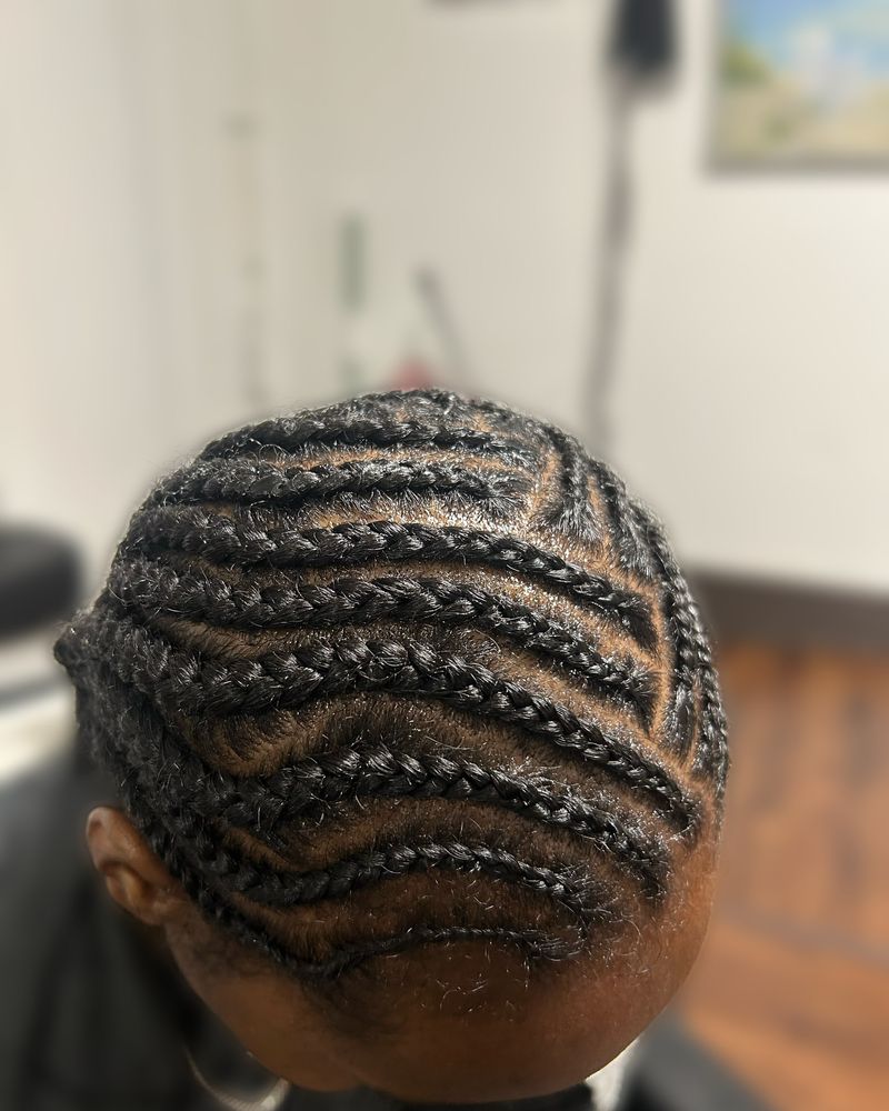Zig-zag cornrows swept to the side, close-up