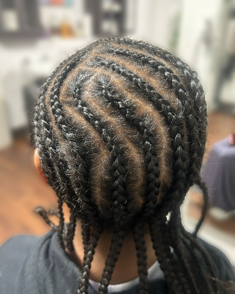 S-curve cornrows flowing into long braids down the back