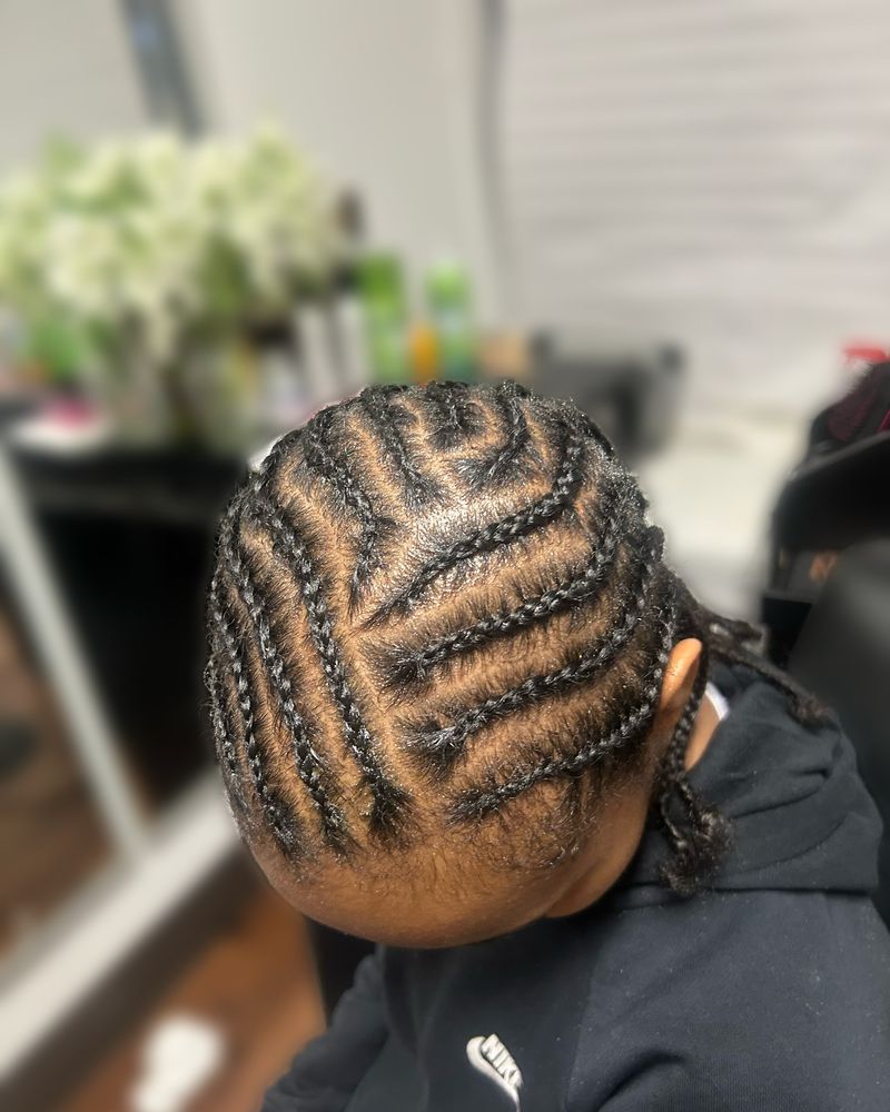 Child's zig-zag cornrows swept to one side