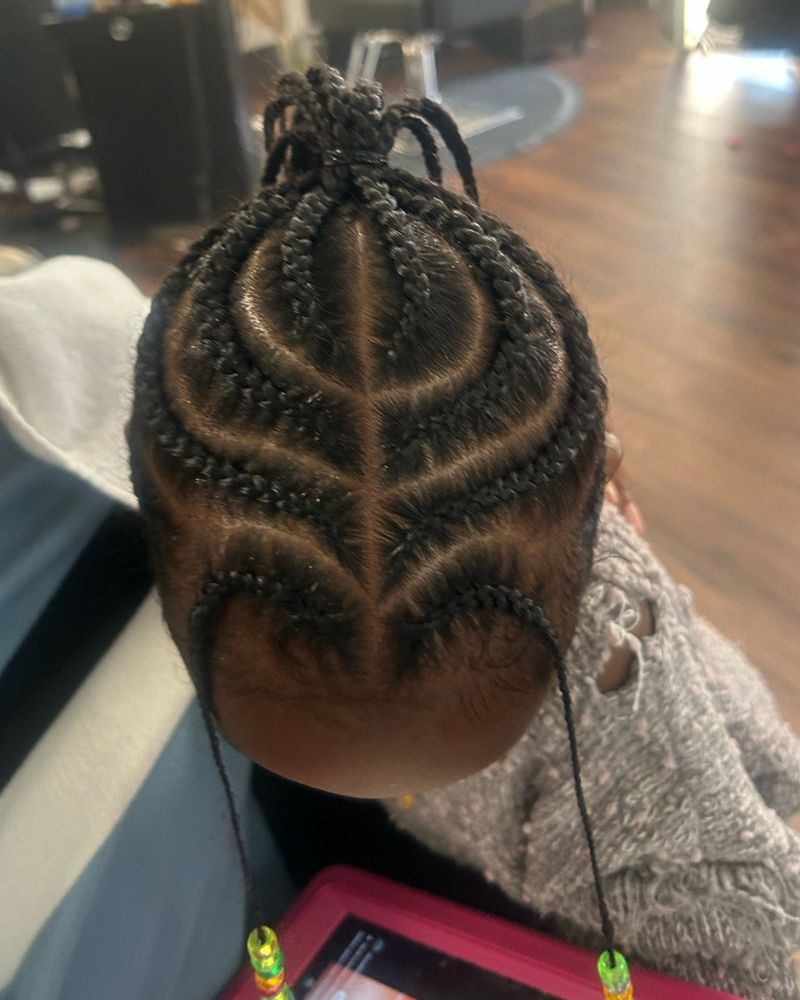 Child's cornrows with a curved heart-shaped center design and beads