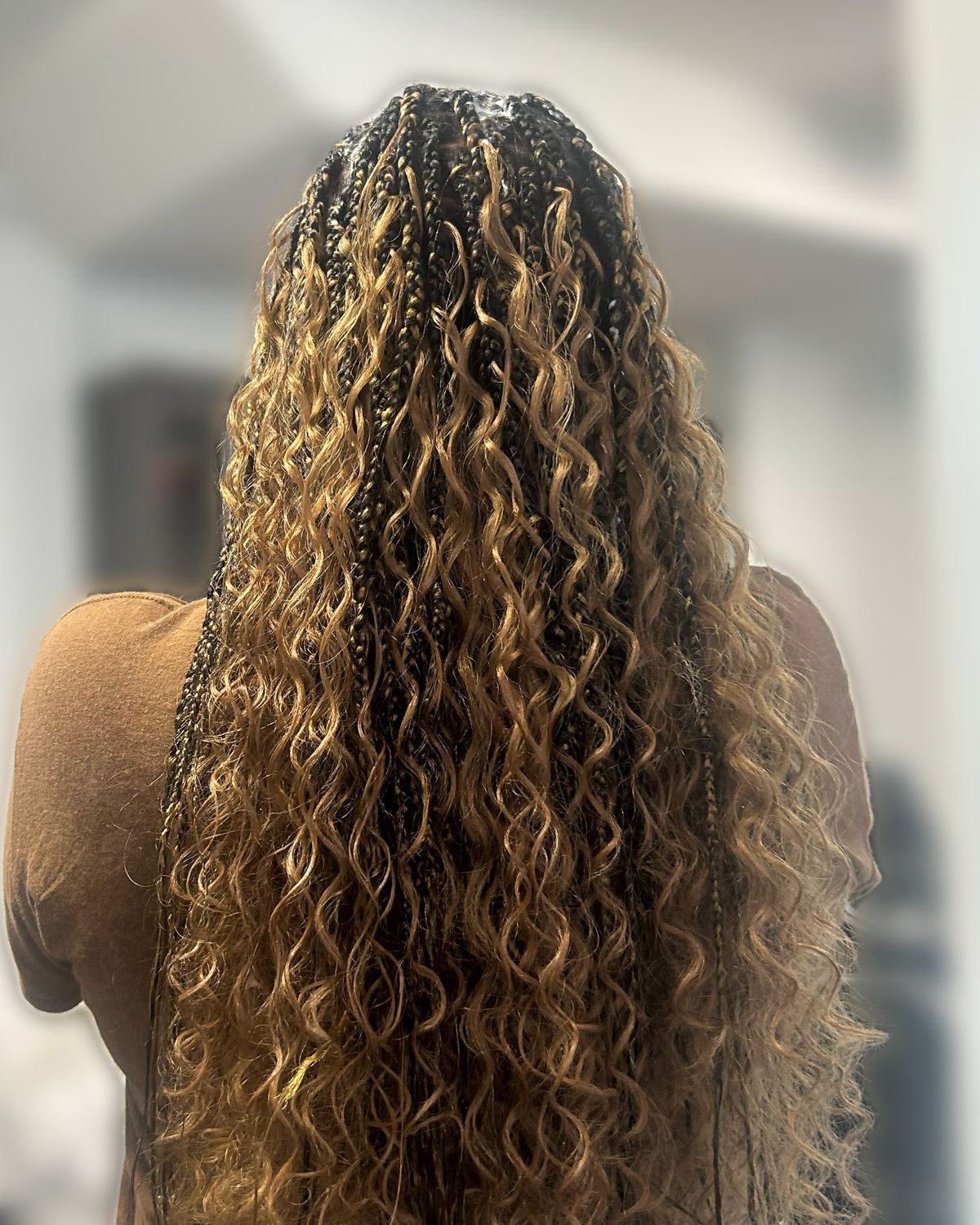 Long boho knotless braids in honey blonde with curly ends