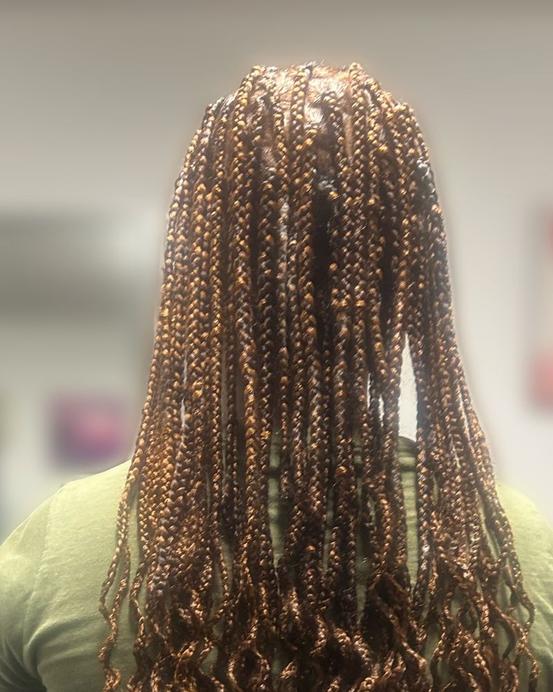 Waist-length boho knotless braids in honey blonde and brown with curly ends