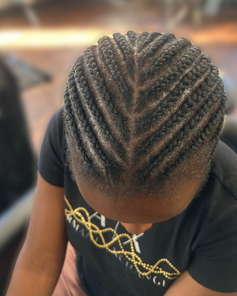 Child's herringbone-style cornrows angled toward the center