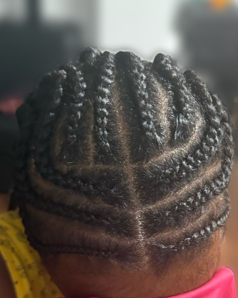 Child's curved cornrows sweeping to the back, close-up